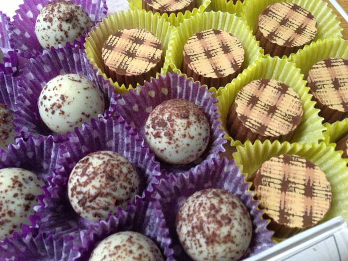 assorted chocolate truffles in purple and yellow cups